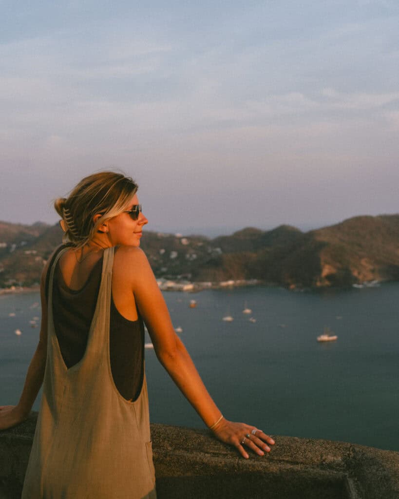 San Juan del Sur, Nicaragua Travel Guide: Worth the Hype? 18 Sally leaning on a stone railing at the Cristo de La Divina Misericordia viewpoint, overlooking the serene bay of San Juan del Sur.