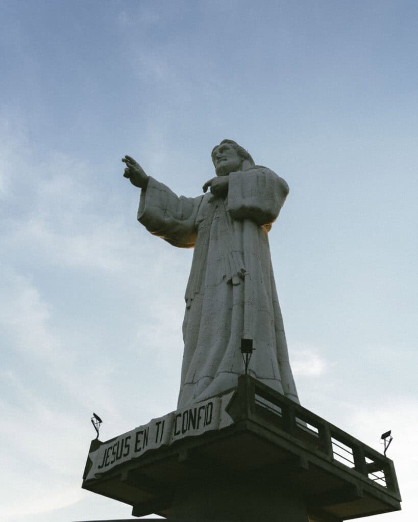 San Juan del Sur, Nicaragua Travel Guide: Worth the Hype? 16 The Cristo de La Divina Misericordia statue in San Juan del Sur, Nicaragua, silhouetted against a soft evening sky.