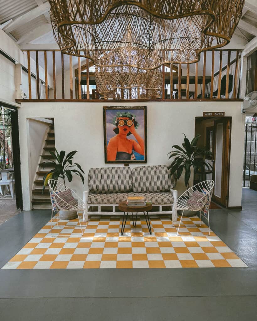 San Juan del Sur, Nicaragua Travel Guide: Worth the Hype? 35 The interior of Ding Repair Cafe, showcasing a vibrant centerpiece painting and wicker chandeliers, with cozy seating in San Juan del Sur.