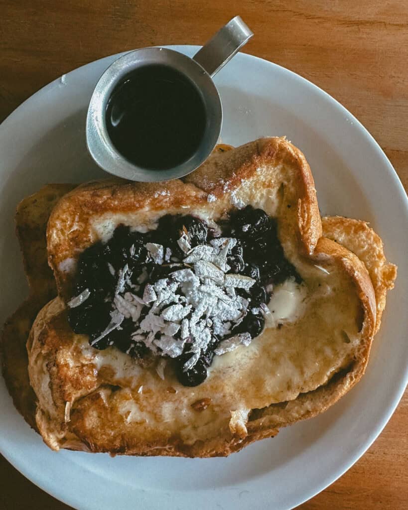 San Juan del Sur, Nicaragua Travel Guide: Worth the Hype? 33 A close up of a plate with French toast, with a berry coulis on top and a metal jug of syrup.