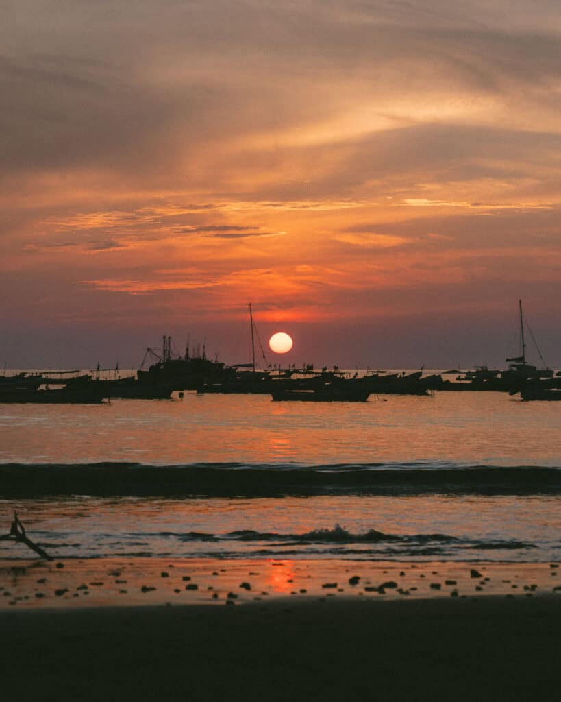 San Juan del Sur, Nicaragua Travel Guide: Worth the Hype? 6 A fiery sunset over the ocean in San Juan del Sur, with boats moored offshore.