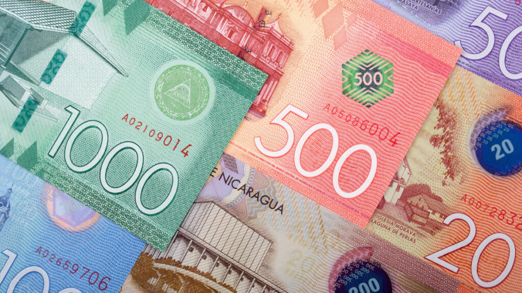 Nicaragua Travel Guide: Land of Lakes and Volcanoes 40 A close up shot of different denominations of Nicaraguan Cordobas spread across a table, there is a green, red, blue and purple note.