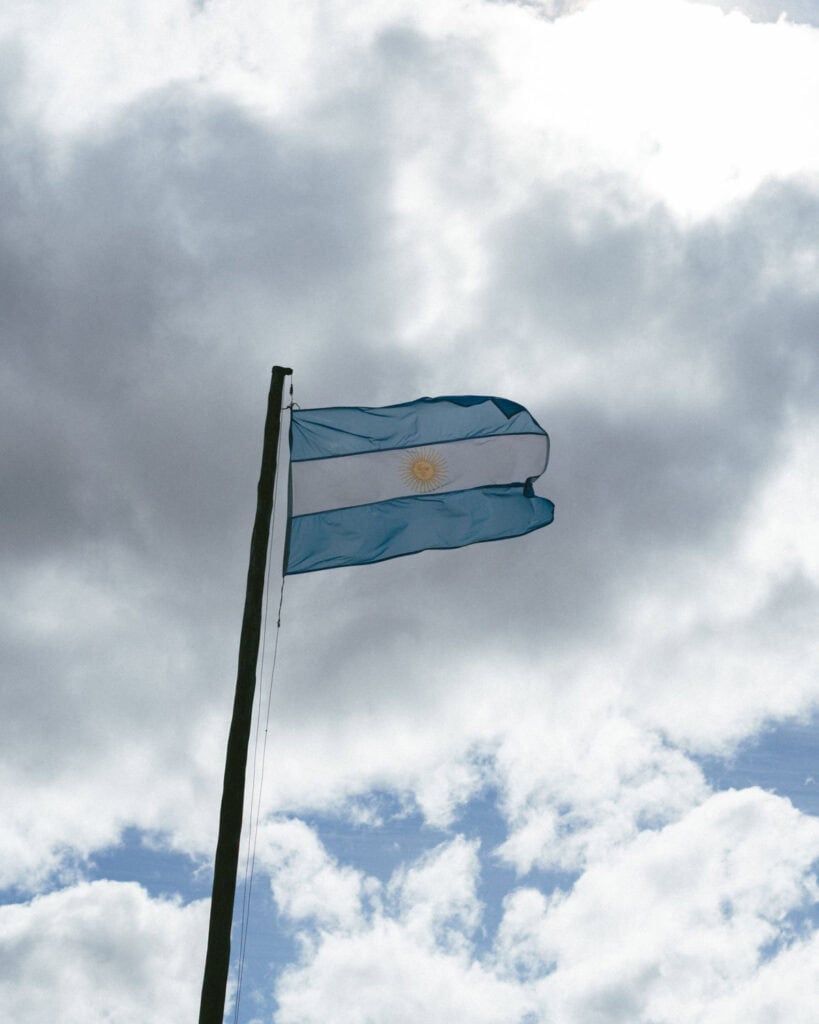The Carretera Austral, Chile: Everything You Need to Know 69 The Argentine flag waves in the wind against a moody sky, representing national pride at the Perito Moreno Glacier in El Calafate