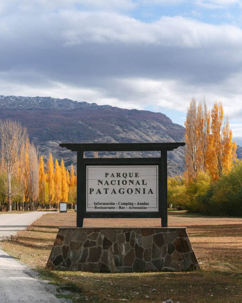 Valle Chacabuco Sector Guide: Parque Nacional Patagonia, Chile 10 Large wooden entrance sign for Parque Nacional Patagonia provides visitor information and is framed by vibrant autumn trees and distant mountains