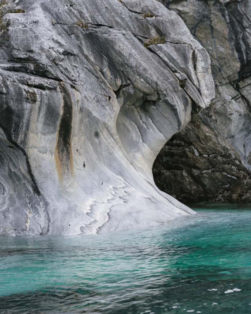 How to Visit the Marble Caves in Chile: Worth the Journey? 1 Close-up of a smooth marble rock face with subtle color variations and waterline markings, captured at Capillas de Mármol in Puerto Río Tranquilo, Chile