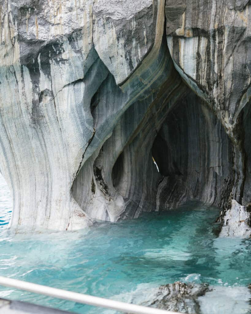 How to Visit the Marble Caves in Chile: Worth the Journey? 30 The swirling, striated walls of the marble caves at Capillas de Mármol tower above the boat-level turquoise water, revealing erosion patterns and natural arches in Puerto Río Tranquilo, Chile