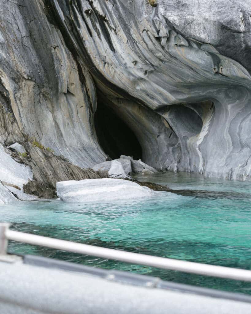 How to Visit the Marble Caves in Chile: Worth the Journey? 21 The view from a boat in Puerto Río Tranquilo shows a close-up of a swirling marble formation and dark cave opening along the Capillas de Mármol