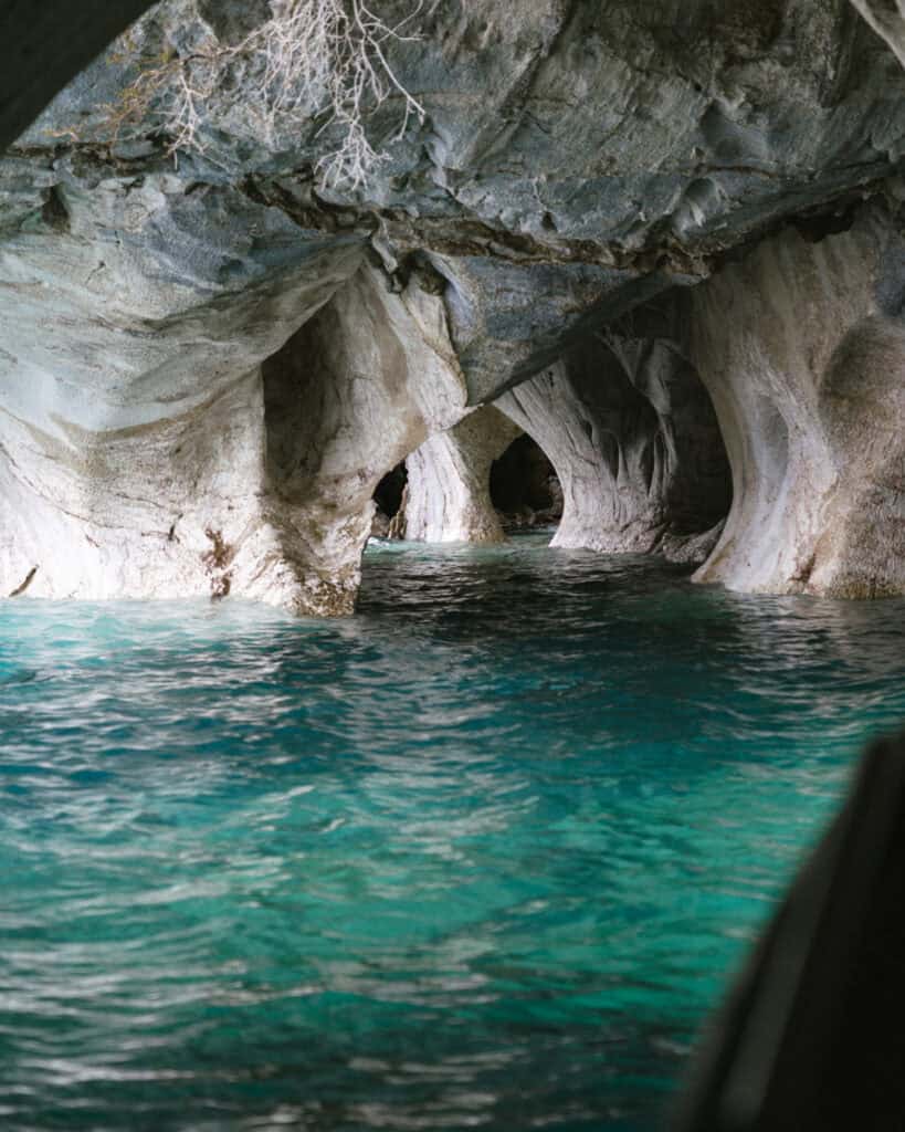 How to Visit the Marble Caves in Chile: Worth the Journey? 35 Bright blue-green water flows through the arches of the Capillas de Mármol caves in Puerto Río Tranquilo, Chile, framed by textured stone columns