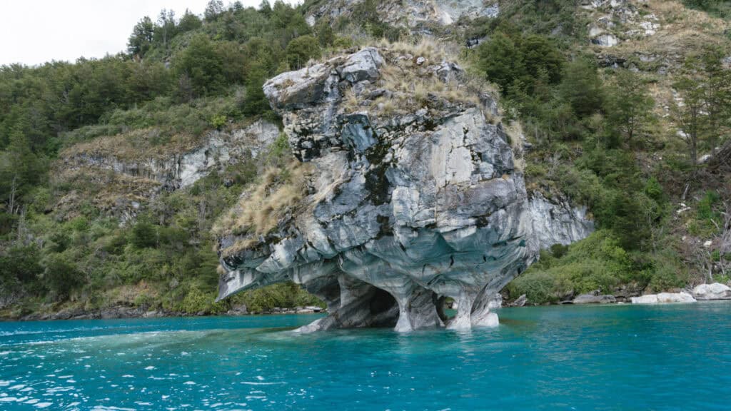 How to Visit the Marble Caves in Chile: Worth the Journey? 4 A uniquely shaped marble islet emerging from the lake, covered in dry grass and vegetation, located near the Marble Caves in Puerto Río Tranquilo
