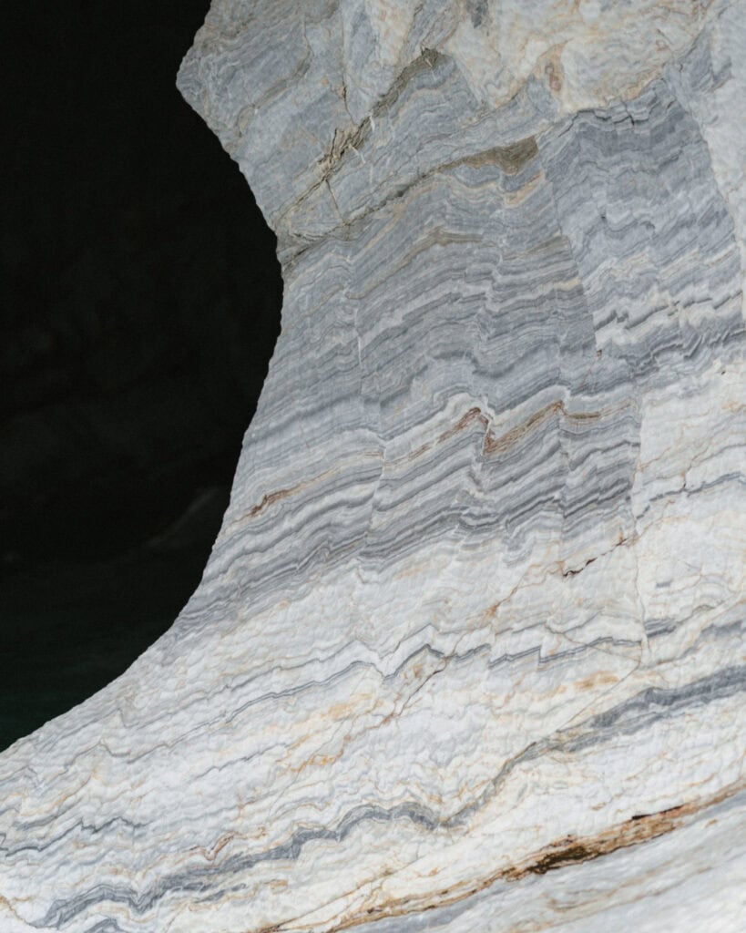 How to Visit the Marble Caves in Chile: Worth the Journey? 31 A soft-colored marble wall with horizontal striations in gray and white inside the Marble Caves, lit by diffused natural light in Puerto Río Tranquilo