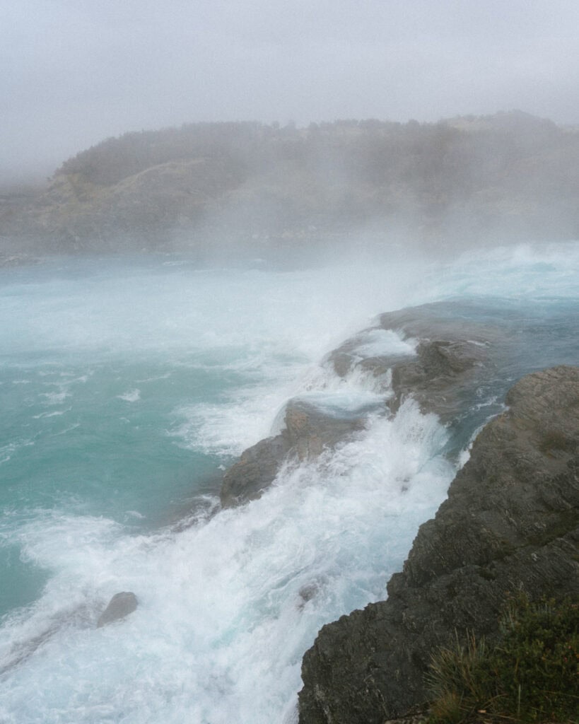 Puerto Rio Tranquilo, Chile Travel Guide: Marble & Ice 35 Turbulent turquoise waves crash against rocky outcrops at the confluence of Río Baker and Río Neff in Puerto Río Tranquilo, with mist rising from the force of the water