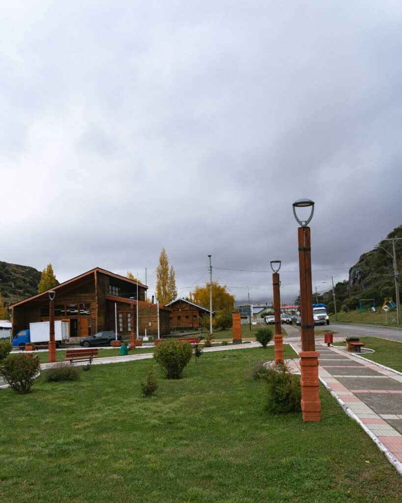 Villa Cerro Castillo, Chile Travel Guide: Hiking & Huemuls 19 Wooden buildings and a landscaped green space with lamp posts and benches make up the small-town plaza in Villa Cerro Castillo, with stormy clouds overhead