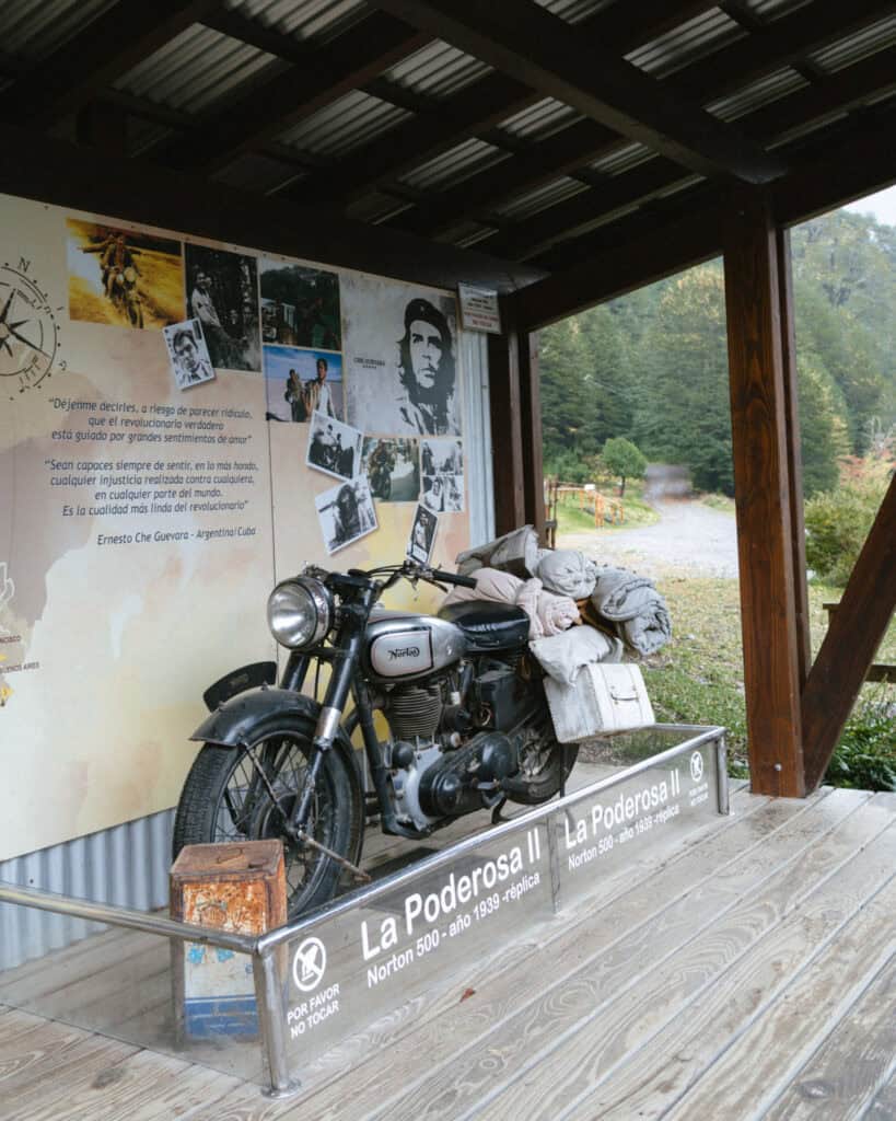 Cruce Andino: The Scenic Route From Chile to Argentina 24 A replica of Che Guevara's 1939 Norton 500 motorbike, "La Poderosa II," is on display under a wooden shelter with photos and quotes in Spanish celebrating his journey
