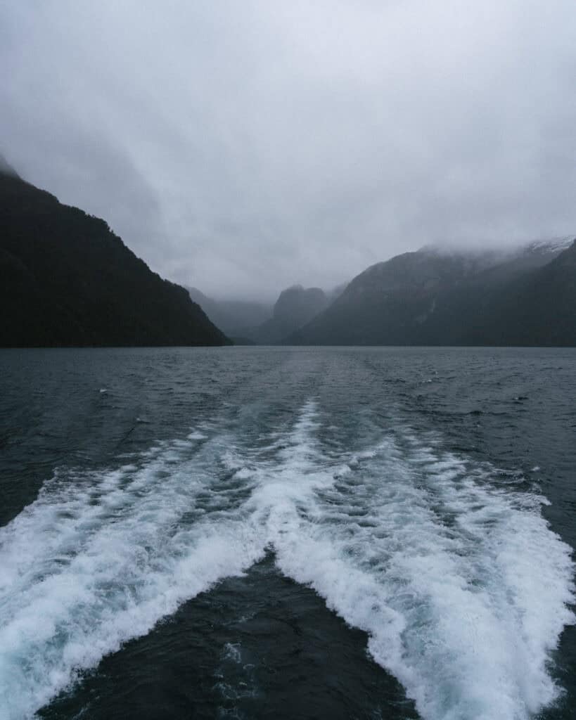 Cruce Andino: The Scenic Route From Chile to Argentina 33 A moody shot from the back of a boat on Lago Nahuel Huapi, showing the churning white wake leading into a valley framed by dark, misty mountains