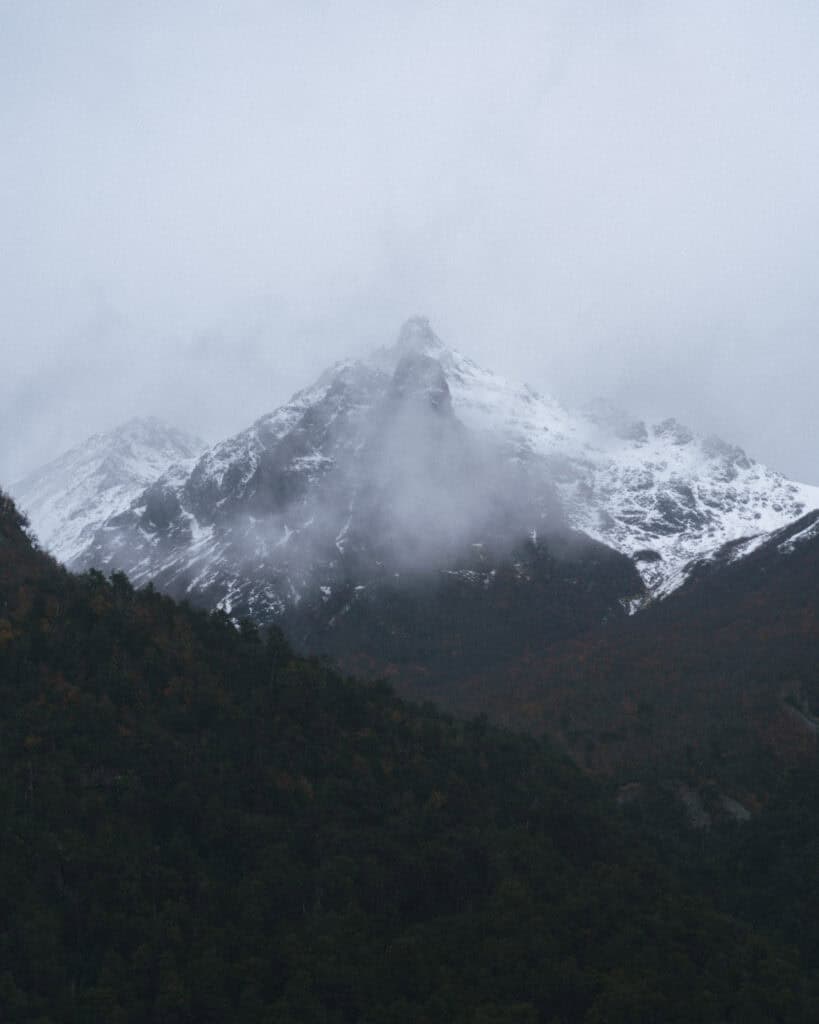 Cruce Andino: The Scenic Route From Chile to Argentina 34 A foggy peak in the Andes looms over Lago Nahuel Huapi, its jagged summit dusted with snow and partially obscured by swirling clouds