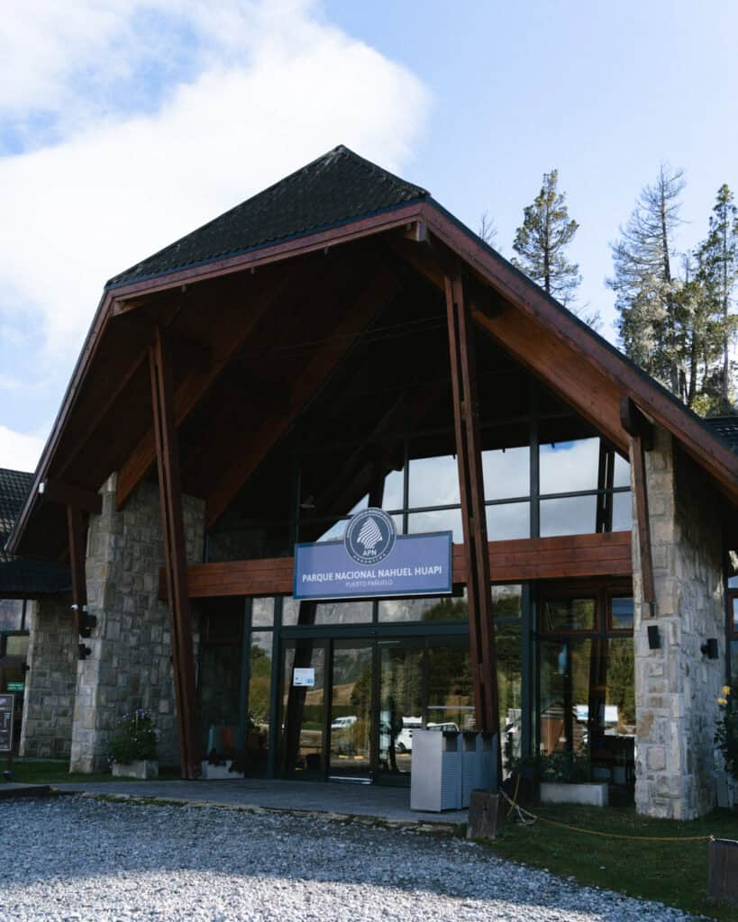 Cruce Andino: The Scenic Route From Chile to Argentina 36 Exterior of the Parque Nacional Nahuel Huapi visitor center in Puerto Pañuelo, featuring stone and wood architecture beneath a blue sky with scattered clouds