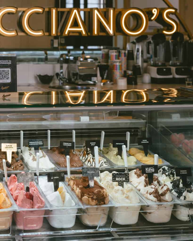 Buenos Aires Food Tour: Sherpa Food Tours in San Telmo 19 A tighter shot of the Lucciano’s gelato display showcasing flavors like pistachio, banana split, cookies & cream, and dulce de leche, each labeled with branded signs.