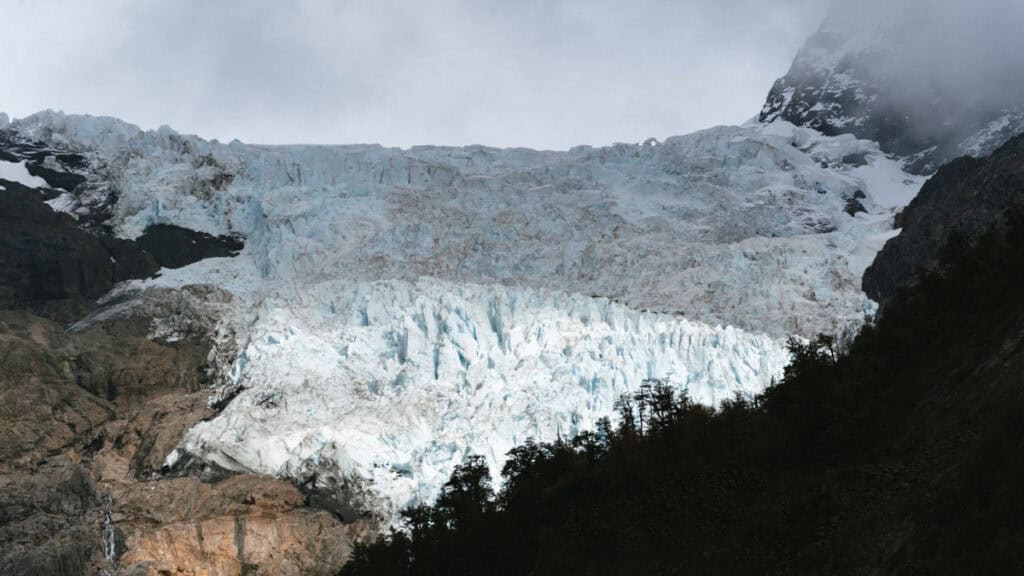 Chaiten, Chile Travel Guide: A Town That Nearly Disappeared 28 Panoramic view of a glacier in Chaitén, Argentina, with jagged blue ice cascading down from a snow-covered mountain surrounded by mist.
