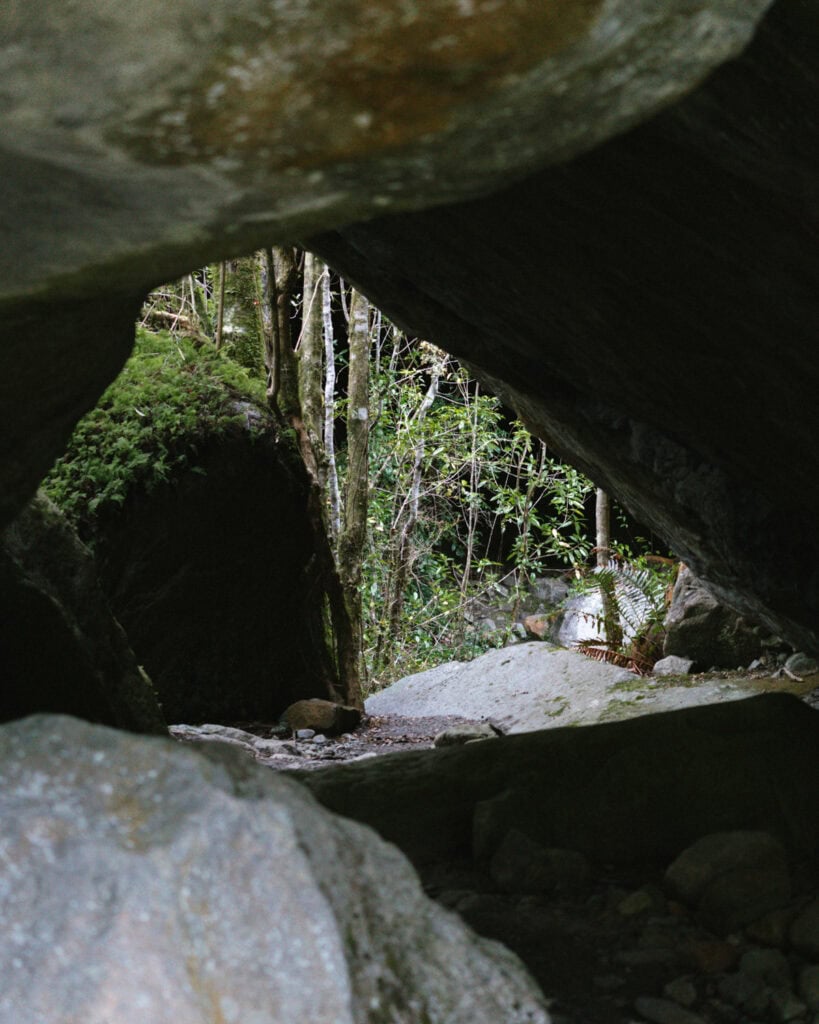 Queulat National Park: How to Visit the Ventisquero Colgante 17 View from inside a rocky cave opening out toward trees and forest light in Puyuhuapi, Chile.
