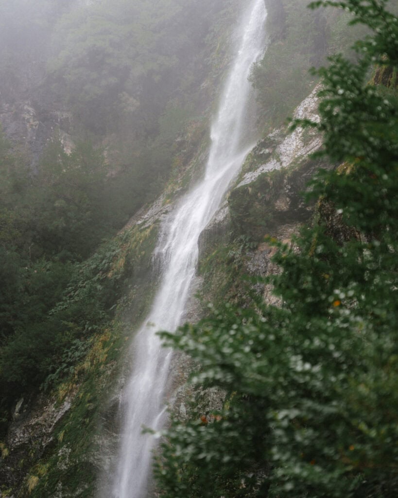 The Carretera Austral, Chile: Everything You Need to Know 33 Close-up of the Queulat waterfall dropping down moss-covered cliffs through fog in Parque Nacional Queulat, Chile.
