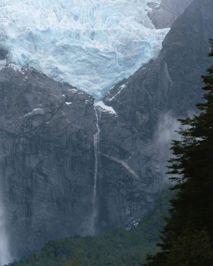 Queulat National Park: How to Visit the Ventisquero Colgante 5 Narrow waterfall streaming from the edge of the Hanging Glacier over dark rock walls in Parque Nacional Queulat, Chile.