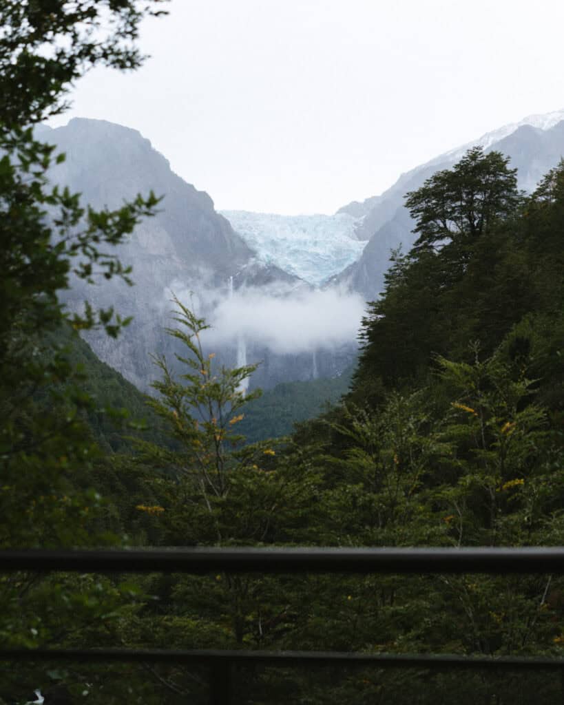 Queulat National Park: How to Visit the Ventisquero Colgante 9 Distant view of Ventisquero Colgante glacier and its waterfalls framed by mist and forest from a lower trail in Parque Nacional Queulat, Chile.