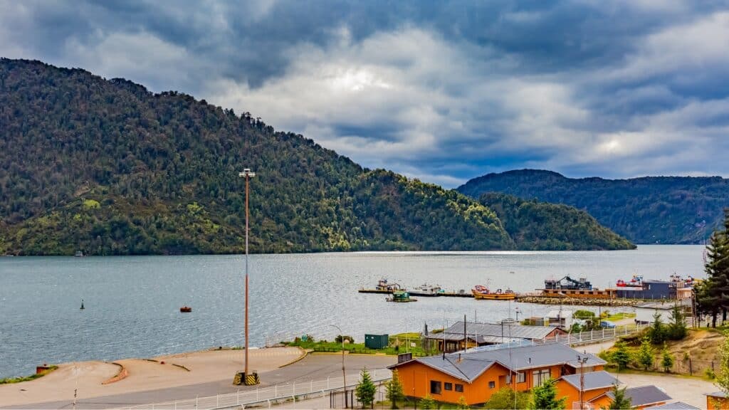 The Carretera Austral, Chile: Everything You Need to Know 35 The small seaside port town of Puerto Chacabuco on the Carretera Austral in Chile, Patagonia. Moody grey skies meet forest clad hills rising up behind the tiny village on the waterfront.