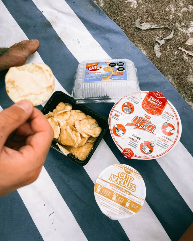 Huasteca Potosina: Guide to Mexico's Waterfall Wonderland 49 Brayden and Sally having a picnic on a blue and white striped towel, with 2 minute noodles and corn chips with cheese sauce in Huasteca Potosina.