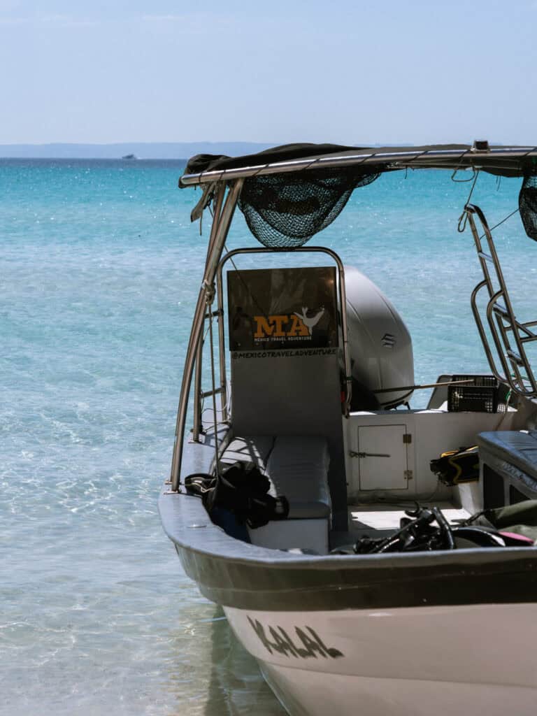Our Day at Isla Espiritu Santo, La Paz: Sea Lions & Beaches 8 A boat rests in shallow water near the shore with visible text "MTA Mexico Travel Adventure" and "@MEXICOTRAVELADVENTURE" on its side at Isla Espiritu Santo in La Paz Baja California Sur.