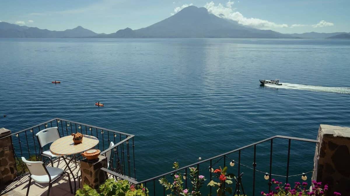 Lake Atitlan Travel Guide: Everything You Need to Know 13 Lakefront terrace with flowers, outdoor seating and panoramic volcano views at La Casa del Mundo in Jaibalito, Lake Atitlán, Guatemala.
